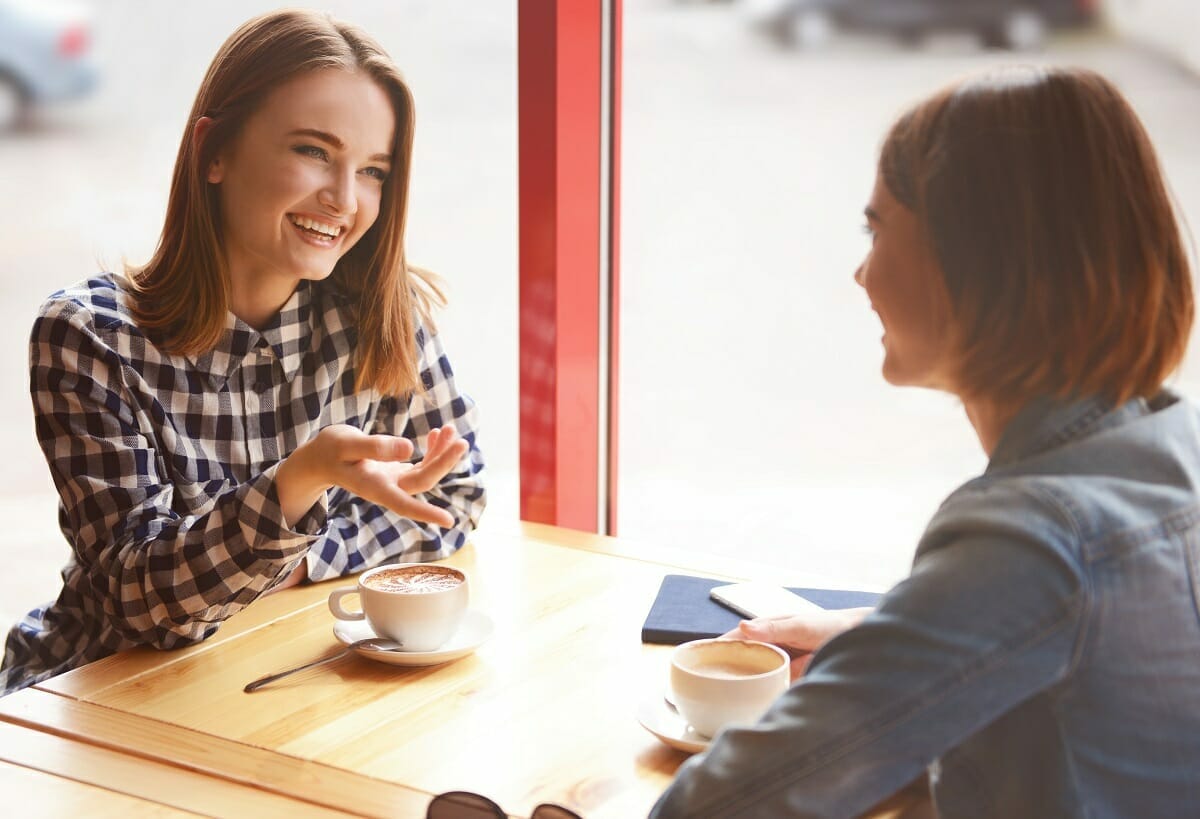 Learn how to connect easily with MANGO - two women in engaged conversation networking at coffee shop