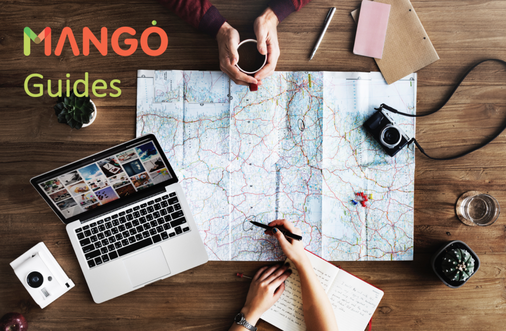 MANGO Career Guides - map, cameras, and laptop on table with two people planning a trip